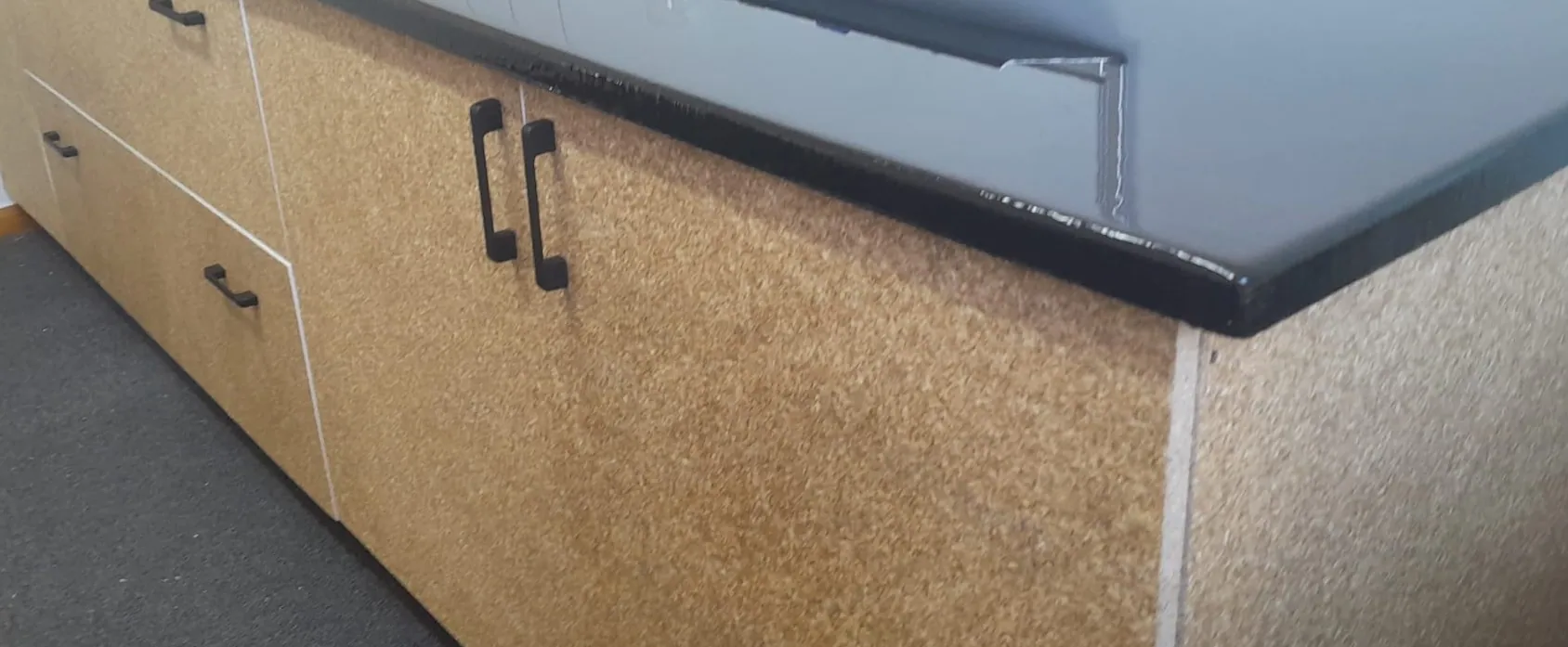Close detail of a hemp-board benchtop and cabinetry edge